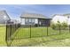 Lush backyard featuring a black metal fence, a view of the screened-in porch, and a well-kept lawn at 15755 Scher Dr, Westfield, IN 46074