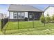 Grassy backyard with a black metal fence, patio with a grill, and a screened-in porch for outdoor enjoyment at 15755 Scher Dr, Westfield, IN 46074