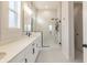 Modern bathroom showcasing a double sink vanity, decorative mirrors, and a glass-enclosed shower with a rain shower head at 15755 Scher Dr, Westfield, IN 46074