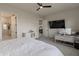 Bright bedroom with a ceiling fan, a large bed, a desk, and an open doorway to the bathroom and kitchen at 15755 Scher Dr, Westfield, IN 46074
