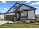 Charming home featuring gray and white colors, complemented by a landscaped front yard and a convenient two-car garage at 15755 Scher Dr, Westfield, IN 46074