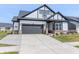 Inviting home featuring a two-car garage, gray and white exterior, and professionally landscaped front yard at 15755 Scher Dr, Westfield, IN 46074