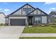 Charming home featuring gray and white colors, complemented by a landscaped front yard and a convenient two-car garage at 15755 Scher Dr, Westfield, IN 46074