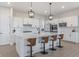 Spacious kitchen island with four stools and pendant lights, with white cabinets and subway tile at 15755 Scher Dr, Westfield, IN 46074