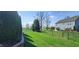 Expansive backyard features a lush lawn, a black chain-link fence, mature trees, and well-maintained landscaping at 1630 Valdarno Dr, Greenwood, IN 46143