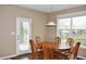 This dining room features an oval wooden table, seating for six, and a window with a view of the backyard at 1630 Valdarno Dr, Greenwood, IN 46143