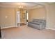 Open-concept living room with plush carpet, a gray sofa, and an elegant chandelier at 1630 Valdarno Dr, Greenwood, IN 46143