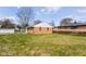 Expansive backyard showcasing the home's exterior, mature trees, and green lawn at 1700 N Tibbs Ave, Indianapolis, IN 46222