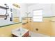 Bathroom featuring a sink, mirror, and fixtures with yellow tile backsplash at 1700 N Tibbs Ave, Indianapolis, IN 46222