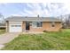 Charming brick ranch home featuring an attached garage and a well-manicured front lawn at 1700 N Tibbs Ave, Indianapolis, IN 46222