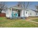 Inviting single-story home with covered porch, painted steps, and two turquoise chairs at 1957 N Colorado Ave, Indianapolis, IN 46218