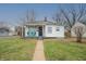 Charming single-story home featuring a cozy front porch with cheerful turquoise chairs at 1957 N Colorado Ave, Indianapolis, IN 46218