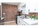 Well-appointed kitchen with modern appliances, white cabinetry, and exposed brick accent wall at 1957 N Colorado Ave, Indianapolis, IN 46218