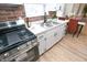 Modern kitchen with stainless steel appliances, white cabinetry, and a brick accent wall at 1957 N Colorado Ave, Indianapolis, IN 46218
