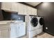 Modern laundry room with white cabinets, sink, countertops, and high-end washer and dryer at 19771 Sutton Ter, Westfield, IN 46074