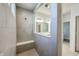 A modern shower showcasing sleek, neutral tile, glass partition, built-in bench, and two windows for natural light at 19771 Sutton Ter, Westfield, IN 46074