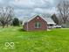 Back view of a brick house with a large, green lawn and mature trees at 2359 S County Road 1050 E, Indianapolis, IN 46231