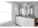 Bathroom with dual sinks, granite countertops, framed mirrors, and white cabinets at 2618 Congress St, Carmel, IN 46032
