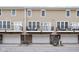 Exterior shot of townhomes with garages and small balconies with black metal railings at 2618 Congress St, Carmel, IN 46032