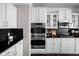Modern kitchen features double ovens, sleek black backsplash and white cabinets, with plenty of counter space at 2618 Congress St, Carmel, IN 46032