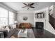Cozy living room featuring a fireplace, large windows, hardwood floors and ceiling fan at 2618 Congress St, Carmel, IN 46032