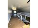 Attic space with hardwood flooring, natural light from a skylight and window, and access to the stairwell at 2627 Chase St, Anderson, IN 46016