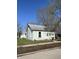 Charming light-blue home with a well-maintained lawn and mature trees on a clear, sunny day at 2627 Chase St, Anderson, IN 46016