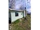 A side exterior view of the home with light green siding, showcasing the window and roof details at 2627 Chase St, Anderson, IN 46016