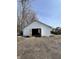 Exterior shot of a white detached garage with two open doors and a dirt lot at 2627 Chase St, Anderson, IN 46016