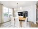 Bright dining room with large window, wooden table, white chairs, and modern light fixture at 3246 Fawn Cir, Brownsburg, IN 46112