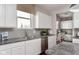 Bright kitchen with white cabinets, gray tile backsplash, granite countertops, and stainless steel appliances at 3246 Fawn Cir, Brownsburg, IN 46112