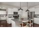 Open kitchen with center island, stainless steel appliances, white cabinets, and hardwood floors at 3246 Fawn Cir, Brownsburg, IN 46112