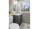 Bathroom features gray vanity, marble floors, round mirror, and a window at 3407 Allison Ave, Indianapolis, IN 46224