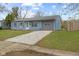 Charming blue single-story home with a gray trim and a crushed gravel driveway at 3407 Allison Ave, Indianapolis, IN 46224