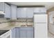 Well-lit kitchen with light blue cabinets, stainless steel sink and white appliances at 3407 Allison Ave, Indianapolis, IN 46224