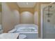 Bathroom featuring large tub with white tile surround and glass enclosed shower at 355 E Ohio St # 310, Indianapolis, IN 46204