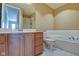 Bright bathroom with a large vanity, granite countertop, soaking tub, and tile floor at 355 E Ohio St # 310, Indianapolis, IN 46204