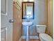 Cozy powder room featuring pedestal sink, framed mirror, and neutral color scheme at 355 E Ohio St # 310, Indianapolis, IN 46204