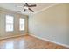 Sunlit bedroom featuring hardwood floors, a ceiling fan, and two windows at 355 E Ohio St # 310, Indianapolis, IN 46204