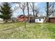 Backyard featuring a detached garage and a mix of green grass and chain link fencing at 3559 Carrollton Ave, Indianapolis, IN 46205