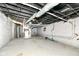 Unfinished basement with painted walls and exposed ceiling and plumbing, ready to be transformed at 3559 Carrollton Ave, Indianapolis, IN 46205