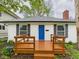 Welcoming home showcasing a bright blue door and a lovely wood porch at 3559 Carrollton Ave, Indianapolis, IN 46205