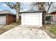 A detached one car garage with a white door and concrete driveway offers secure parking and storage at 3559 Carrollton Ave, Indianapolis, IN 46205