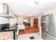 This view of the kitchen gives a full view of the dining area, living room, and stainless steel refrigerator at 3559 Carrollton Ave, Indianapolis, IN 46205