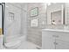 Well-lit bathroom featuring marble tiling, updated vanity, and a shower with tub combination at 358 Terrace Ave, Indianapolis, IN 46225