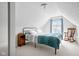 Cozy bedroom with slanted ceiling and window view; features a comfortable bed, rocking chair, and night stand at 358 Terrace Ave, Indianapolis, IN 46225