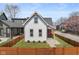 Charming home featuring a fenced yard, freshly cut grass, and a quaint front porch with bright orange door at 358 Terrace Ave, Indianapolis, IN 46225