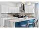 Kitchen island with granite countertop and seating, complemented by modern appliances and white cabinets at 358 Terrace Ave, Indianapolis, IN 46225