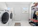 Well-lit laundry room showcasing modern washer/dryer units and organized storage with tiled flooring at 358 Terrace Ave, Indianapolis, IN 46225