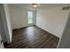 A brightly lit bedroom featuring hardwood floors, a window to the outside, and white painted walls at 3734 Ontario Cir, Indianapolis, IN 46268